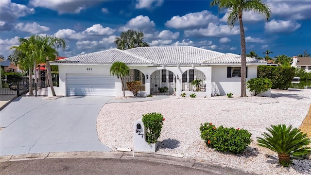 927 Golf Island Dr, Apollo Beach, FL 33572 - mediterranean / spanish-style house with a garage, stucco siding, driveway, covered porch, and fence