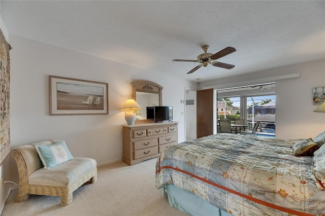 927 Golf Island Dr, Apollo Beach, FL 33572 - carpeted bedroom featuring access to exterior, a textured ceiling, a ceiling fan, and baseboards