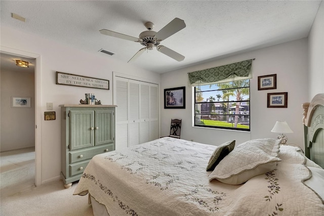 927 Golf Island Dr, Apollo Beach, FL 33572 - bedroom with light carpet, a closet, a ceiling fan, and a textured ceiling