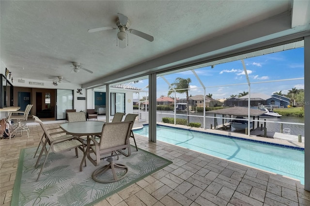 927 Golf Island Dr, Apollo Beach, FL 33572 - swimming pool featuring a ceiling fan, a patio, glass enclosure, and a water view