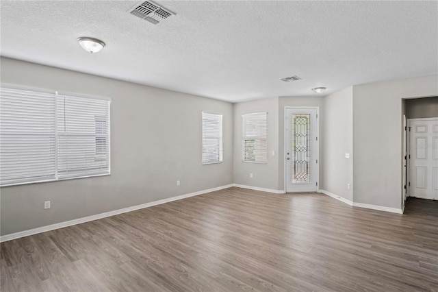 18837 Litzau Ln, Land O Lakes, FL 34638 - unfurnished room with a textured ceiling, wood finished floors, and baseboards