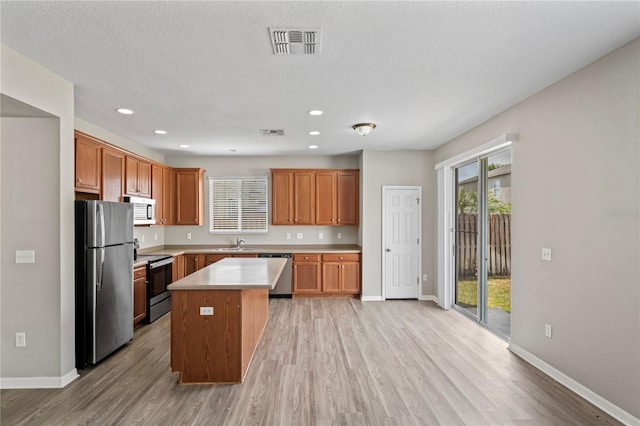 18837 Litzau Ln, Land O Lakes, FL 34638 - kitchen with stainless steel appliances, light wood-style floors, light countertops, baseboards, and recessed lighting