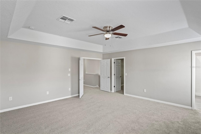 18837 Litzau Ln, Land O Lakes, FL 34638 - unfurnished bedroom featuring a tray ceiling, carpet floors, baseboards, a walk in closet, and ensuite bathroom