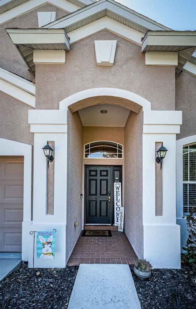 view of exterior entry with stucco siding