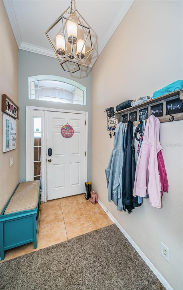 entryway with light colored carpet, an inviting chandelier, baseboards, light tile patterned floors, and ornamental molding