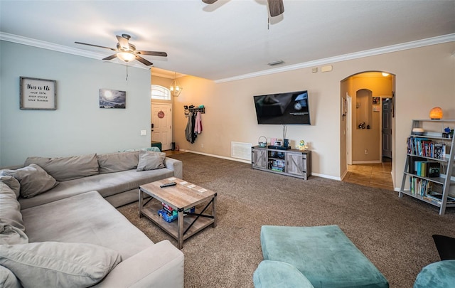 living room featuring carpet flooring, arched walkways, ceiling fan, and ornamental molding