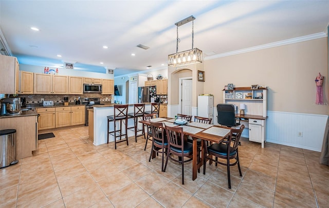 dining area featuring crown molding, wainscoting, light tile patterned flooring, and visible vents