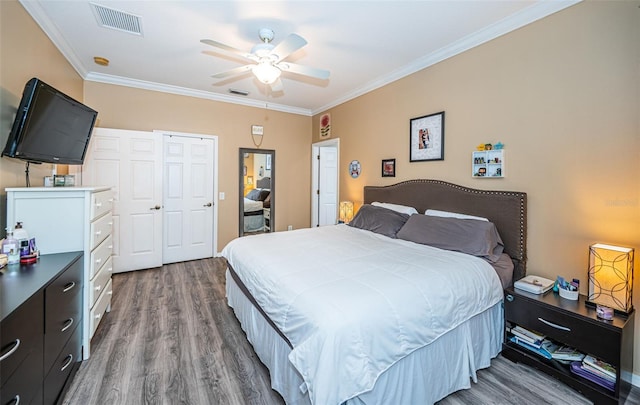 bedroom featuring ornamental molding, wood finished floors, and visible vents