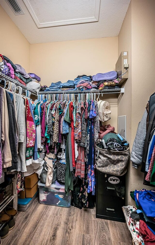 spacious closet featuring attic access, wood finished floors, and visible vents