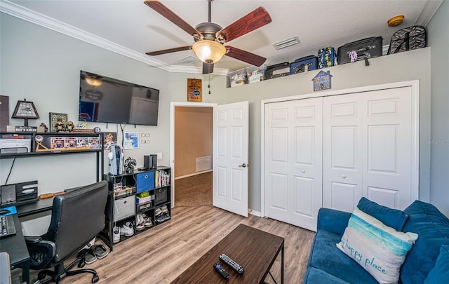 office area featuring visible vents, crown molding, wood finished floors, baseboards, and a ceiling fan