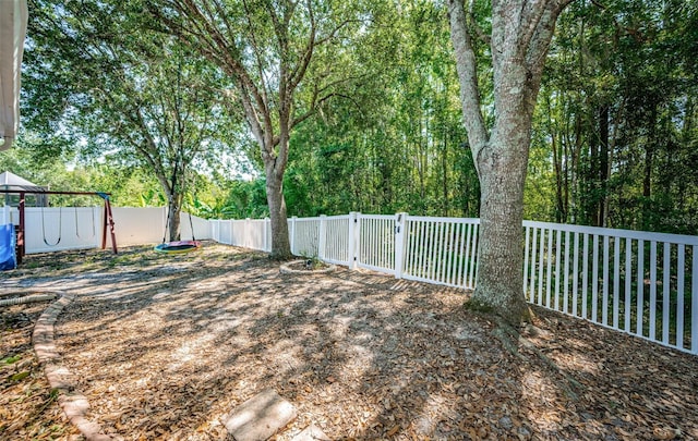 view of yard featuring a fenced backyard and a playground
