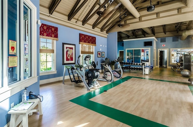 exercise room featuring high vaulted ceiling, a ceiling fan, baseboards, wood finished floors, and wood ceiling