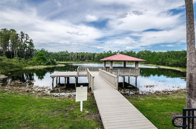 dock area with a water view, a gazebo, and a wooded view