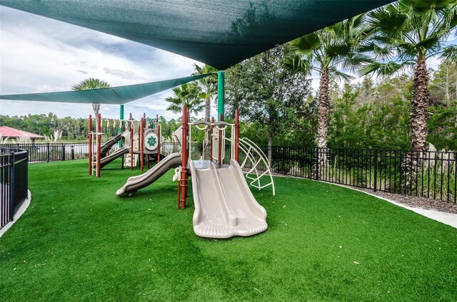 communal playground featuring fence and a yard