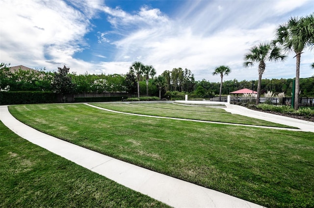 view of community with a lawn and fence