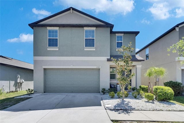 traditional-style home featuring a garage, stucco siding, and driveway