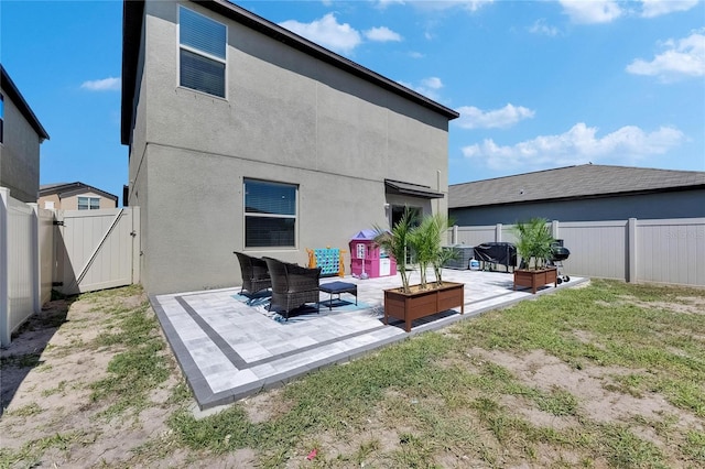 back of house with a patio, a gate, a fenced backyard, and stucco siding