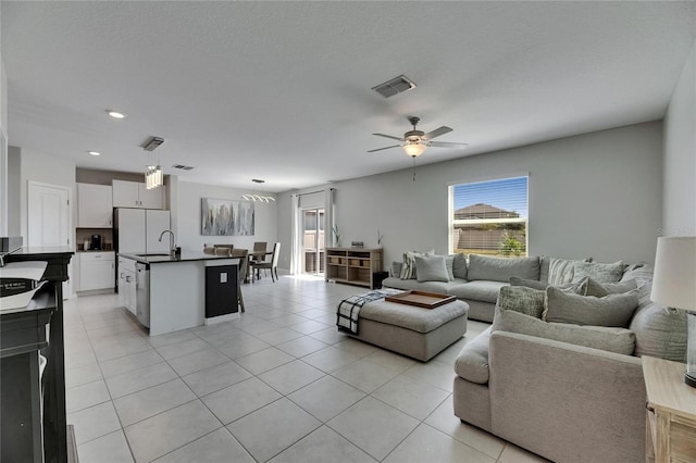 living area featuring visible vents, light tile patterned floors, and a healthy amount of sunlight