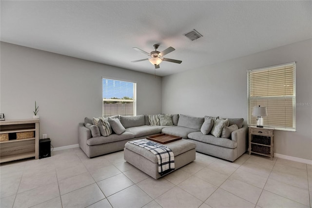living room featuring visible vents, a ceiling fan, baseboards, and light tile patterned floors
