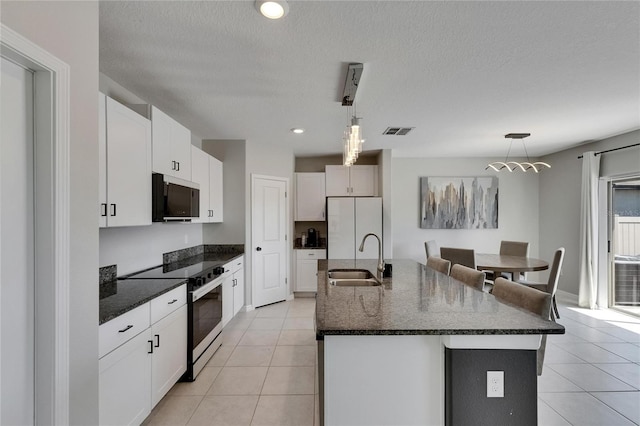 kitchen featuring light tile patterned flooring, a sink, electric range oven, freestanding refrigerator, and visible vents