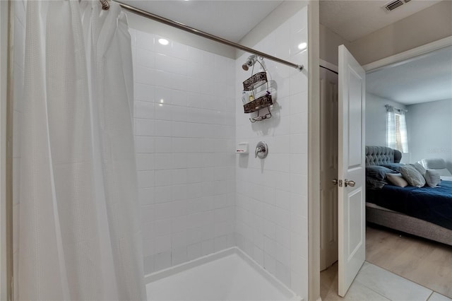ensuite bathroom featuring visible vents, a tile shower, ensuite bathroom, and tile patterned flooring