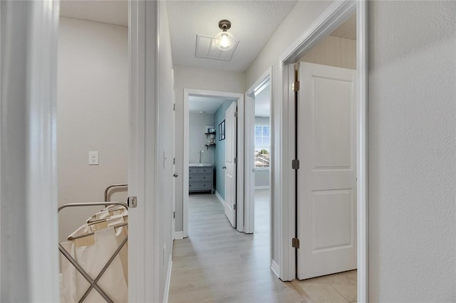 corridor featuring light wood-style floors and baseboards