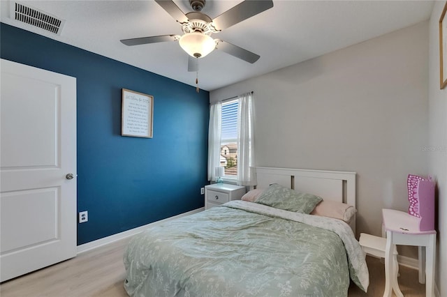 bedroom with visible vents, baseboards, ceiling fan, and wood finished floors