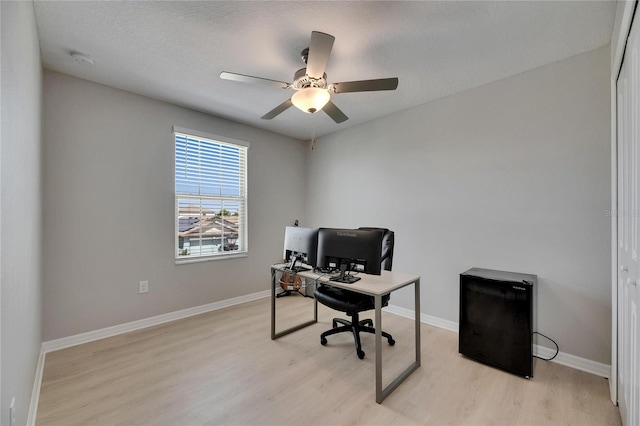 home office featuring baseboards, a ceiling fan, and light wood finished floors