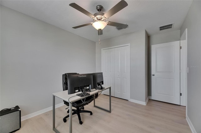 home office with baseboards, visible vents, ceiling fan, and light wood finished floors