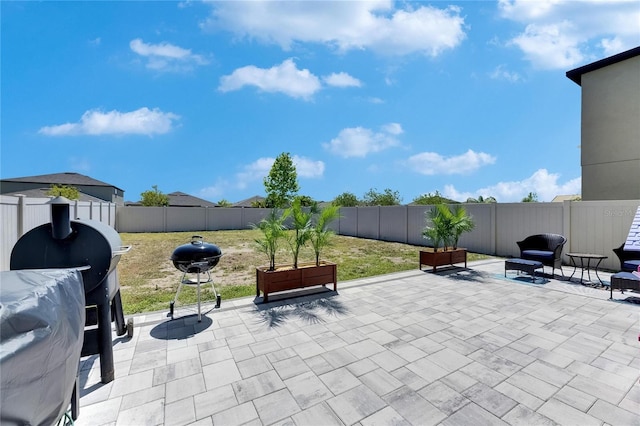 view of patio with area for grilling and a fenced backyard