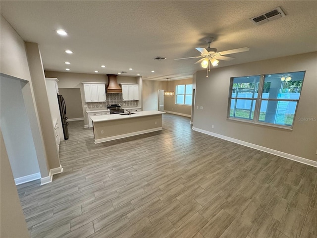37565 Teri Ct, Dade City, FL 33525 - kitchen with a ceiling fan, custom exhaust hood, open floor plan, appliances with stainless steel finishes, and visible vents