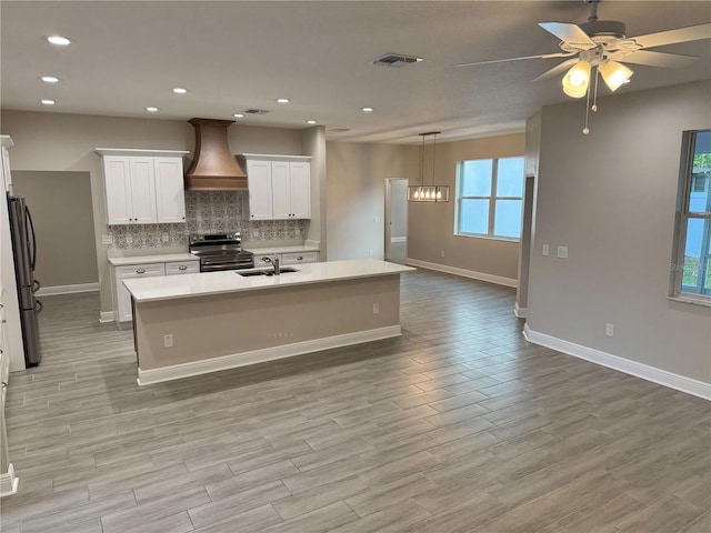 37565 Teri Ct, Dade City, FL 33525 - kitchen featuring a sink, visible vents, baseboards, custom exhaust hood, and appliances with stainless steel finishes