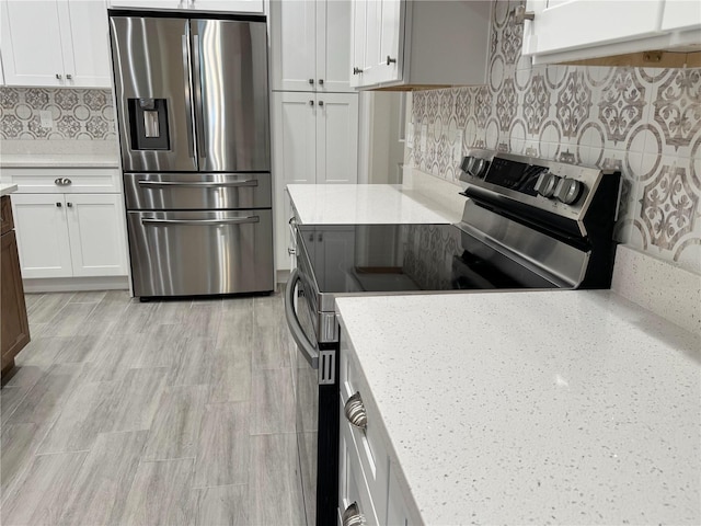 37565 Teri Ct, Dade City, FL 33525 - kitchen with backsplash, appliances with stainless steel finishes, and white cabinetry
