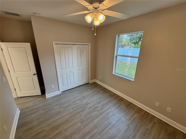 37565 Teri Ct, Dade City, FL 33525 - unfurnished bedroom with wood finished floors, a closet, ceiling fan, baseboards, and visible vents