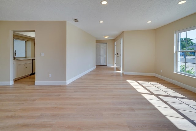 6528 Santiago Ct, Apollo Beach, FL 33572 - empty room with recessed lighting, visible vents, light wood-type flooring, baseboards, and a textured ceiling
