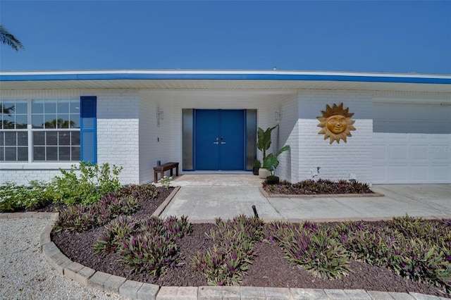 6528 Santiago Ct, Apollo Beach, FL 33572 - property entrance with an attached garage, brick siding, and a porch