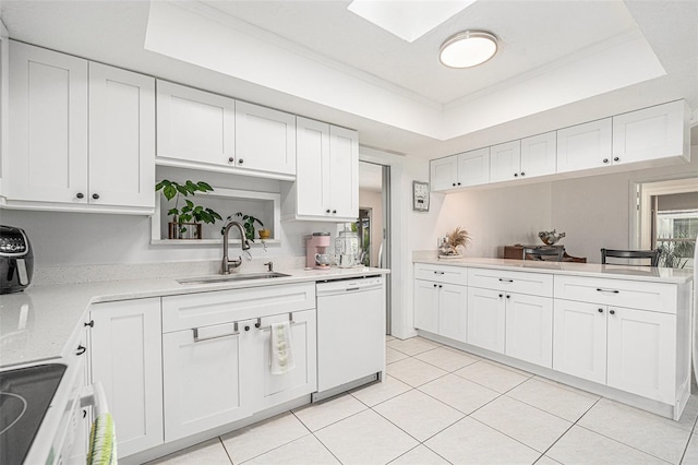 kitchen featuring light countertops, a raised ceiling, dishwasher, a sink, and white cabinetry
