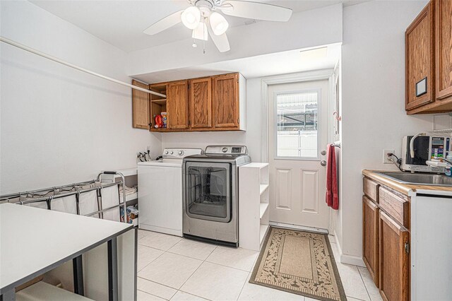 laundry area featuring a ceiling fan, light tile patterned floors, a sink, washer and dryer, and cabinet space
