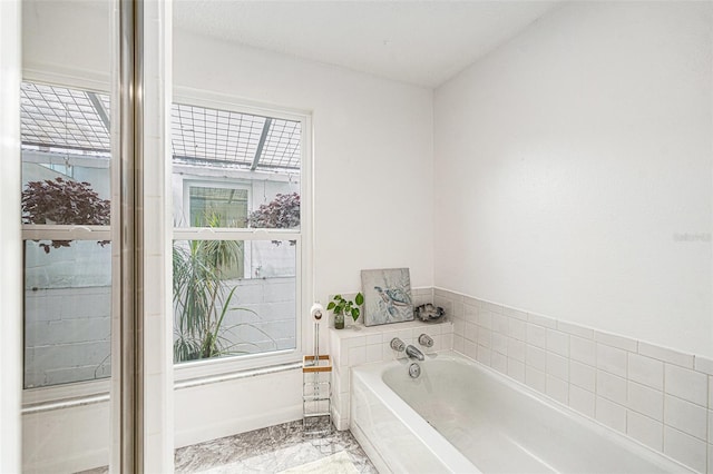 full bath featuring a bath and marble finish floor