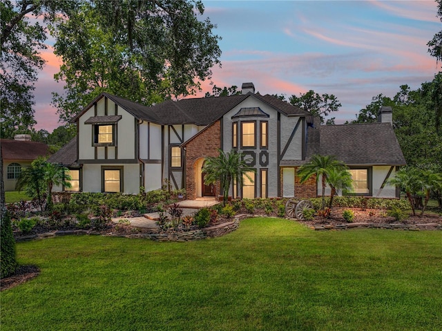 13004 Bell Creek Chase, Riverview, FL 33569 - tudor-style house featuring a lawn, a shingled roof, a chimney, and stucco siding