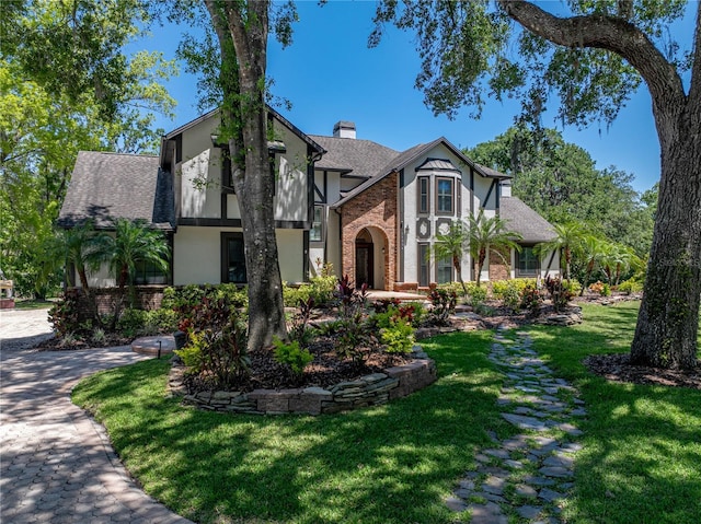 13004 Bell Creek Chase, Riverview, FL 33569 - english style home with a chimney, brick siding, a shingled roof, and a front yard
