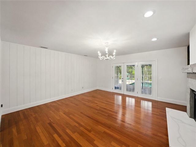 13004 Bell Creek Chase, Riverview, FL 33569 - unfurnished living room with wood finished floors, visible vents, baseboards, a fireplace, and a notable chandelier