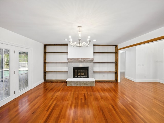 13004 Bell Creek Chase, Riverview, FL 33569 - unfurnished living room featuring recessed lighting, wood finished floors, a premium fireplace, baseboards, and a notable chandelier