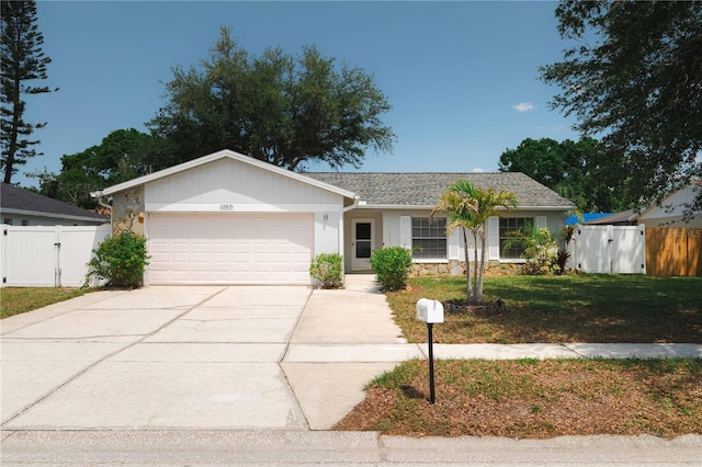 ranch-style house with a gate, concrete driveway, a front lawn, fence, and a garage