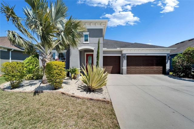 mediterranean / spanish-style house with stucco siding, a front lawn, concrete driveway, and a garage