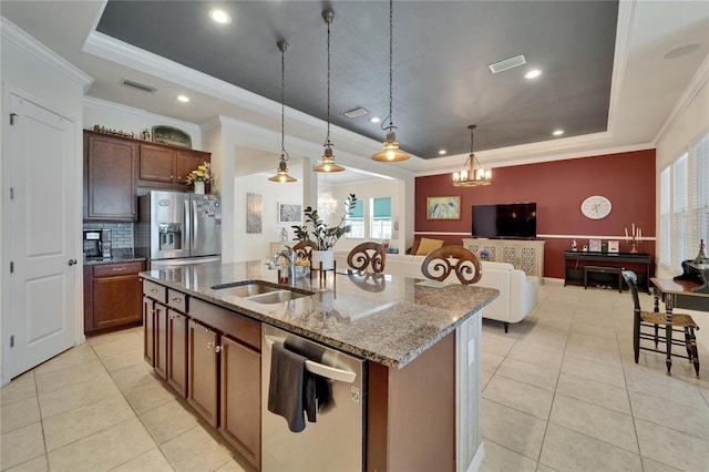 kitchen with a tray ceiling, appliances with stainless steel finishes, light tile patterned flooring, and a sink