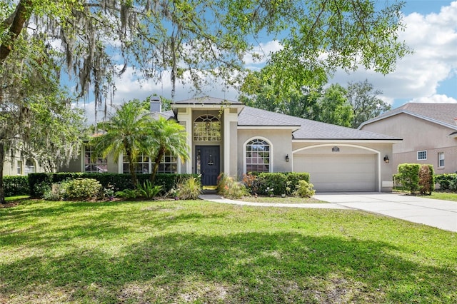 view of front of house with a garage, a front lawn, stucco siding, and driveway