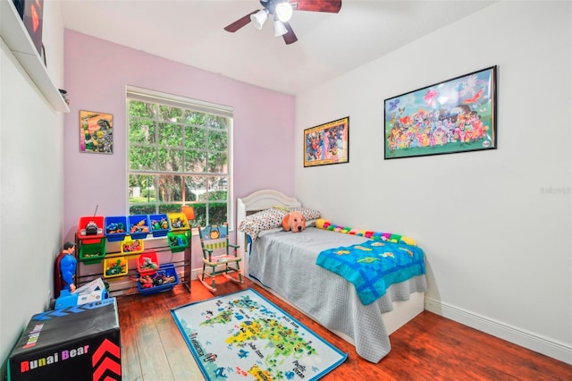 bedroom featuring a ceiling fan, baseboards, and wood finished floors