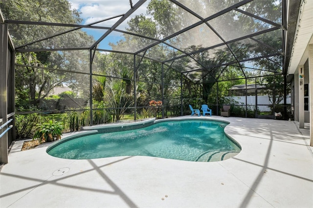 view of pool featuring glass enclosure, a fenced in pool, and a patio area