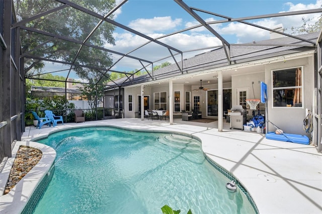 view of pool with a fenced in pool, glass enclosure, ceiling fan, and a patio area